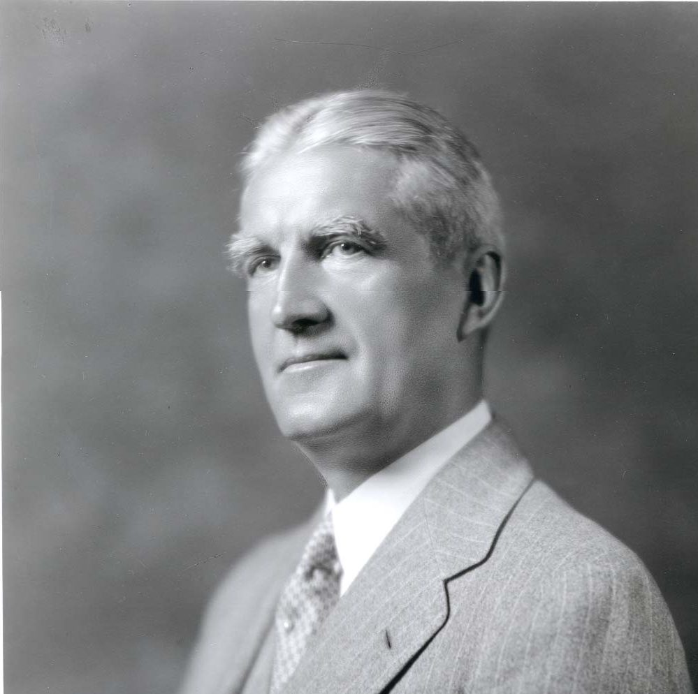 JW McConnell in his sixties, wearing a suit and tie. His hair is grey and his eyebrows are bushy.