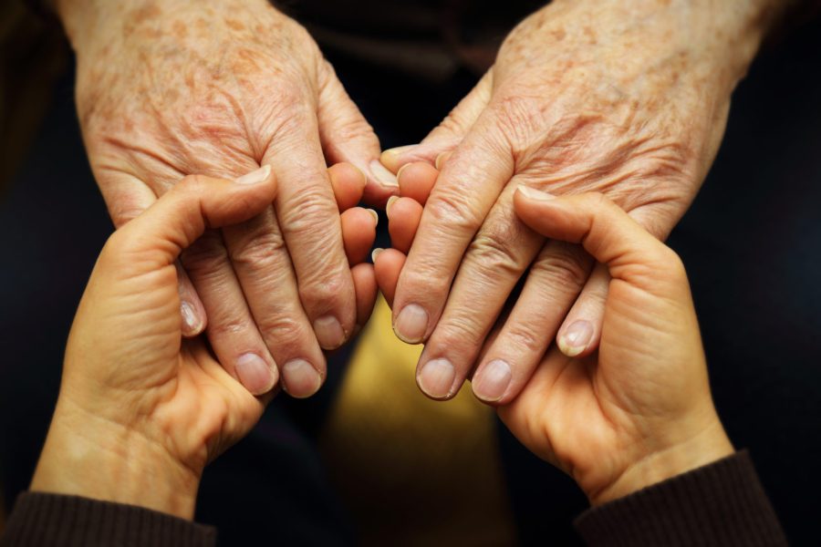 Young hands holding the hands of an elderly person