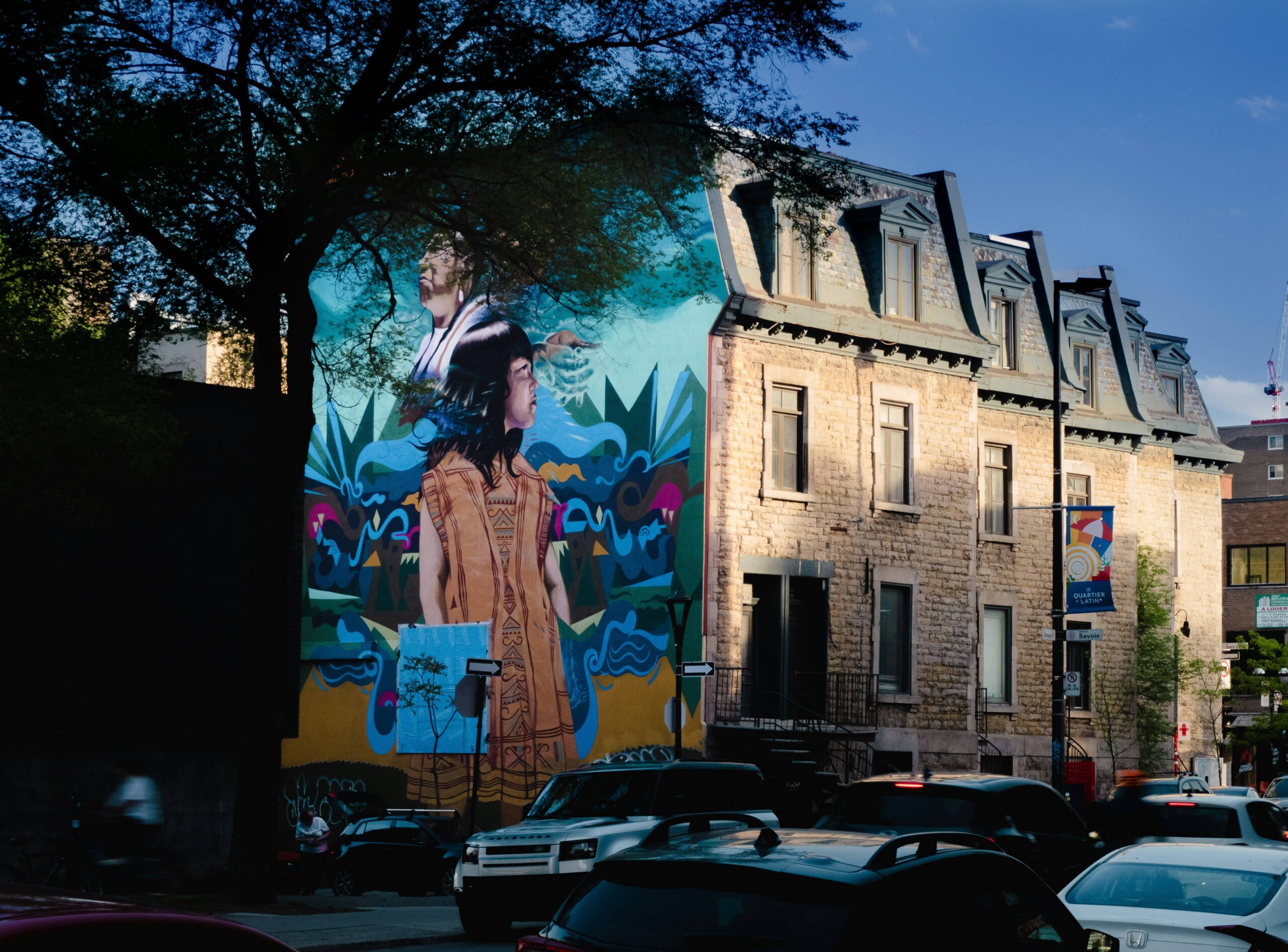Mural of an Indigenous girl and an older Indigenous woman on the side of a building in Montreal.
